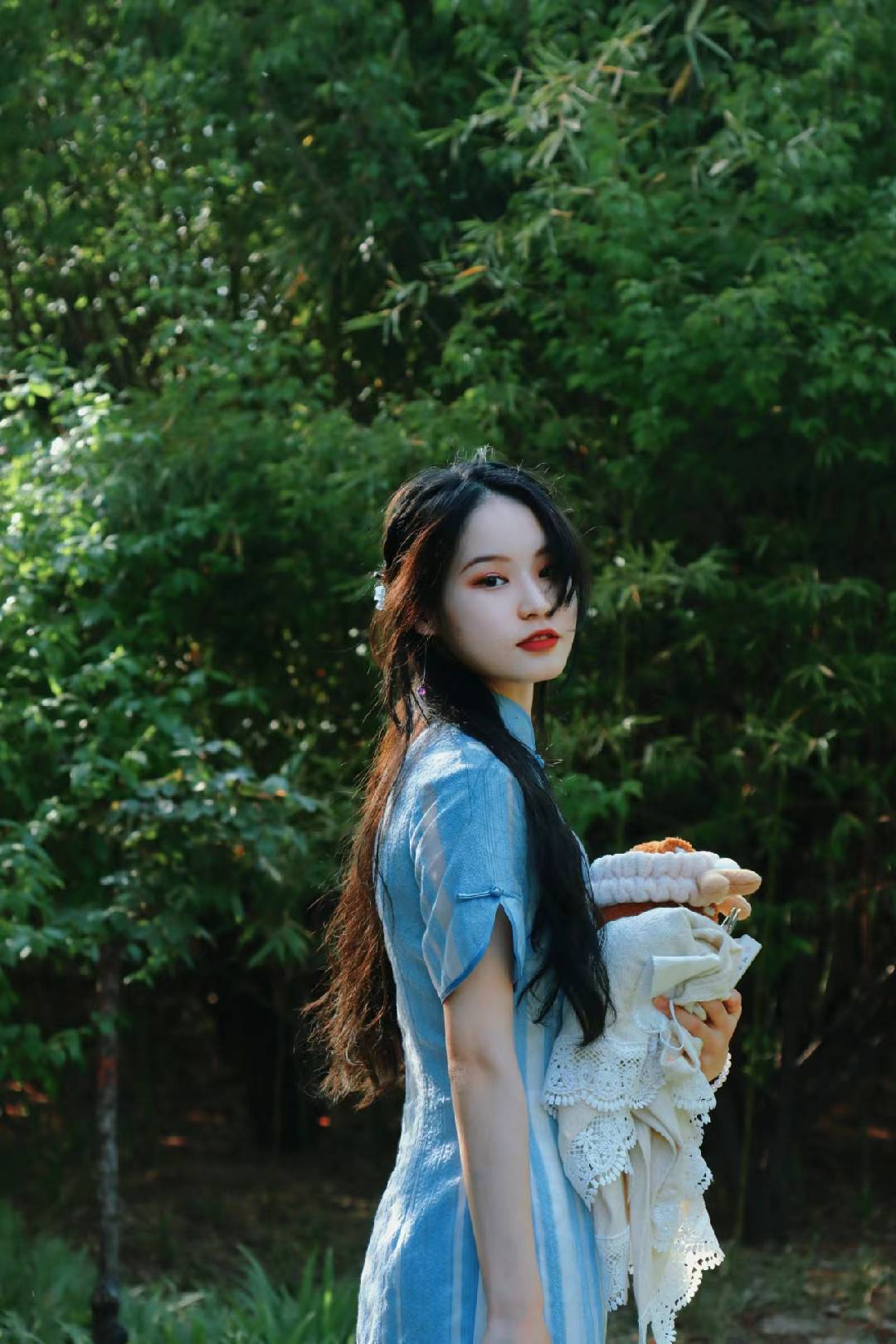 Niandaren in blue, looking back among bamboo